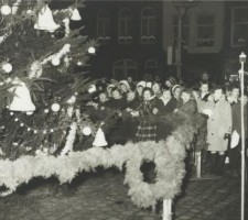 Kinderen bij de kerstboom op de Markt voor het stadhuis tijdens kaarsjesavond, 18 december 1962