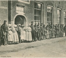 De onderbouw van de Werkinrichting met poserende bewoners en bewoonsters, circa 1910
